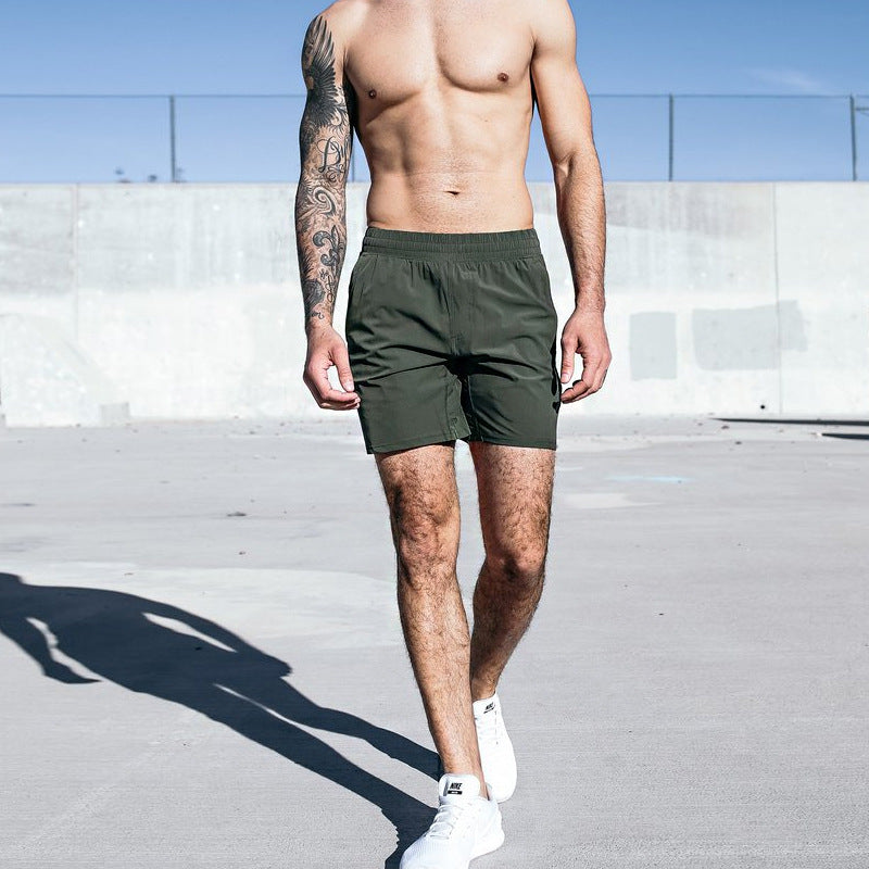 A man wearing army green color Fitness Exercise Beach Leisure Pants a product from mensathletix the best Men athletic shorts Gym shorts Mens running shorts Crossfit shorts Sports shorts sports shorts for mengym shorts