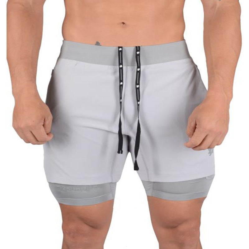 A man wearing ash color ATHX 2-in-1 Gym Run Shorts a product from mensathletix the best Men athletic shorts Gym shorts Mens running shorts Crossfit shorts Sports shorts sports shorts for menMen gym shorts