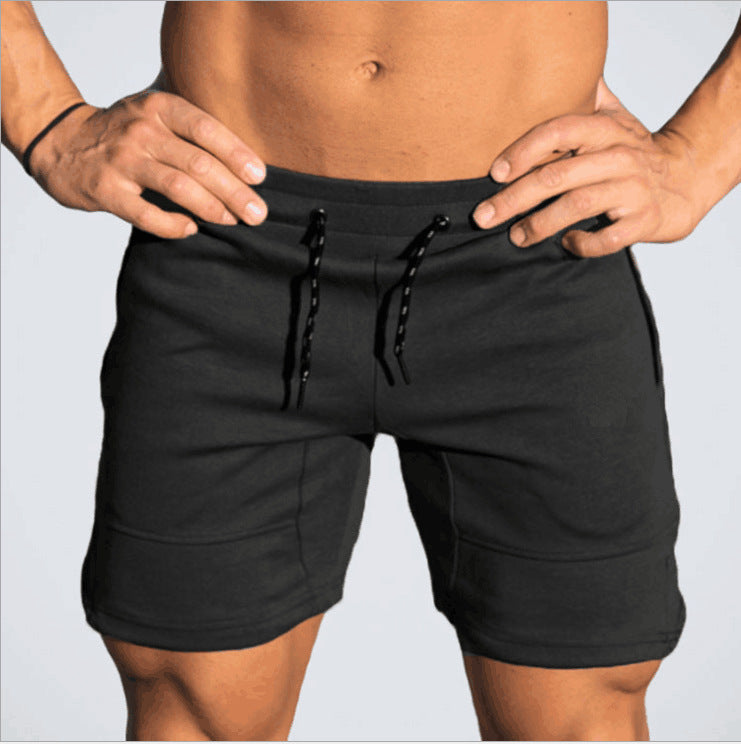 A man wearing black color Casual Drawstring Shorts a product from mensathletix the best Men athletic shorts Gym shorts Mens running shorts Crossfit shorts Sports shorts sports shorts for men gym shorts